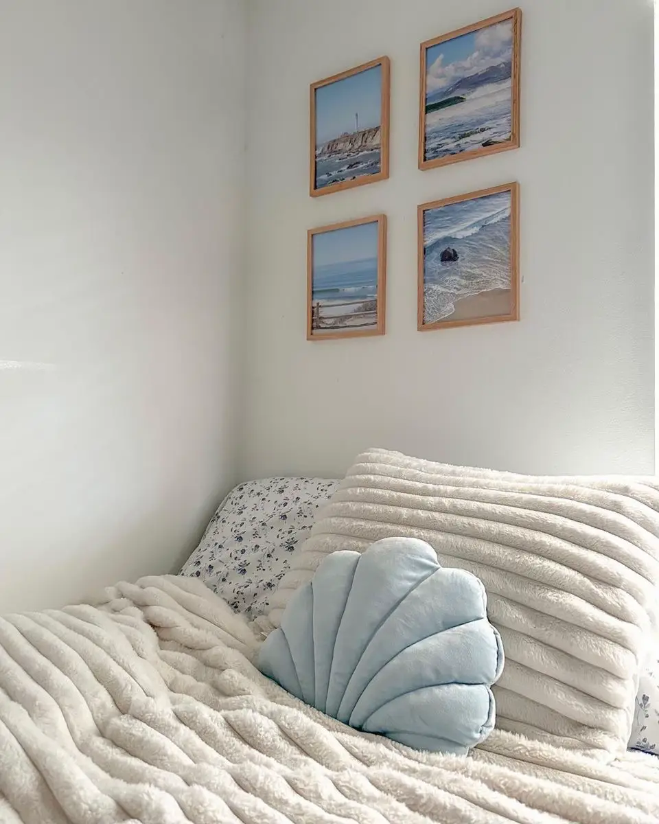  A bed with a white comforter and a picture of the ocean on the wall.