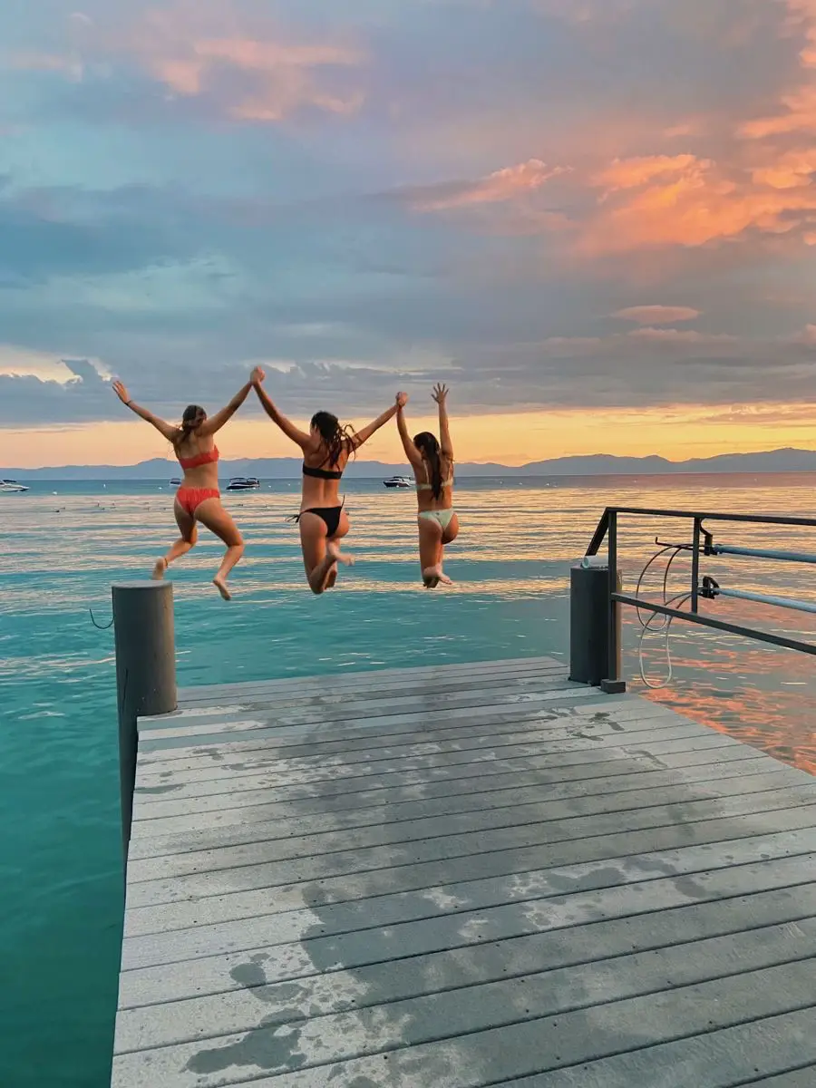  Four women are jumping in the water.
