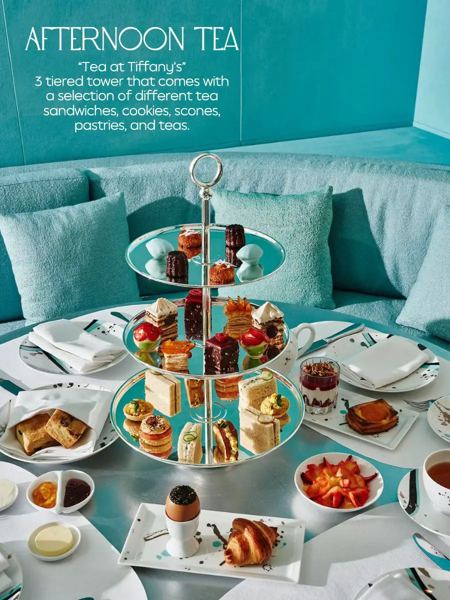  A table with a 3 tiered tower of food and tea