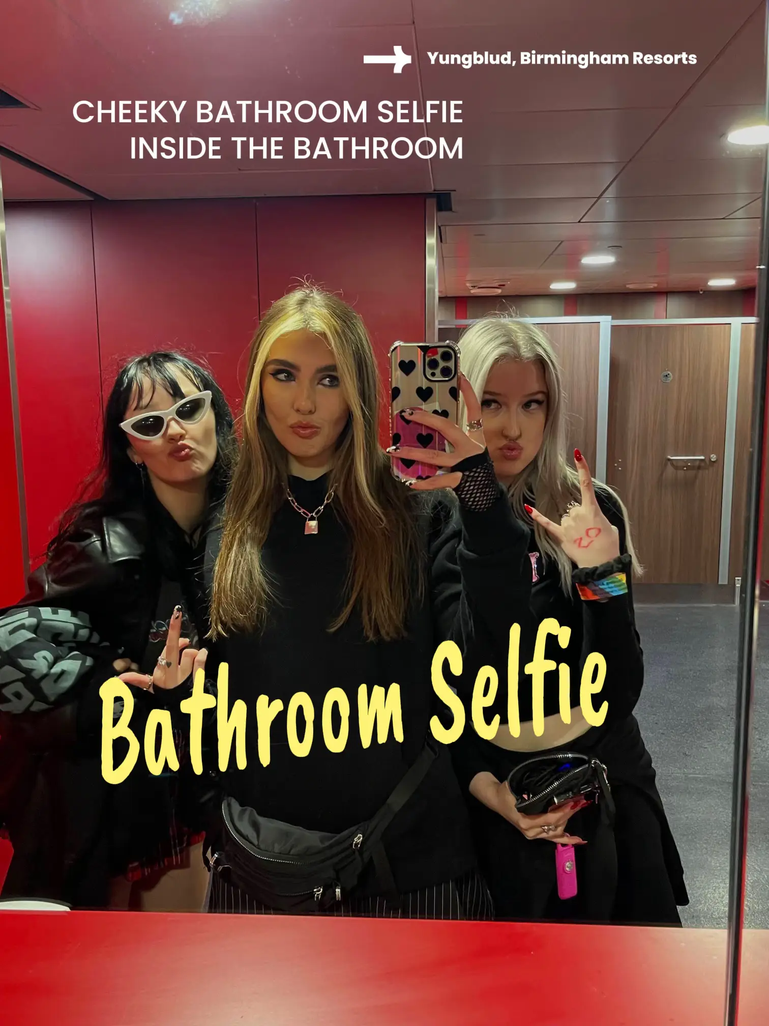  Three women are taking a selfie in a bathroom.