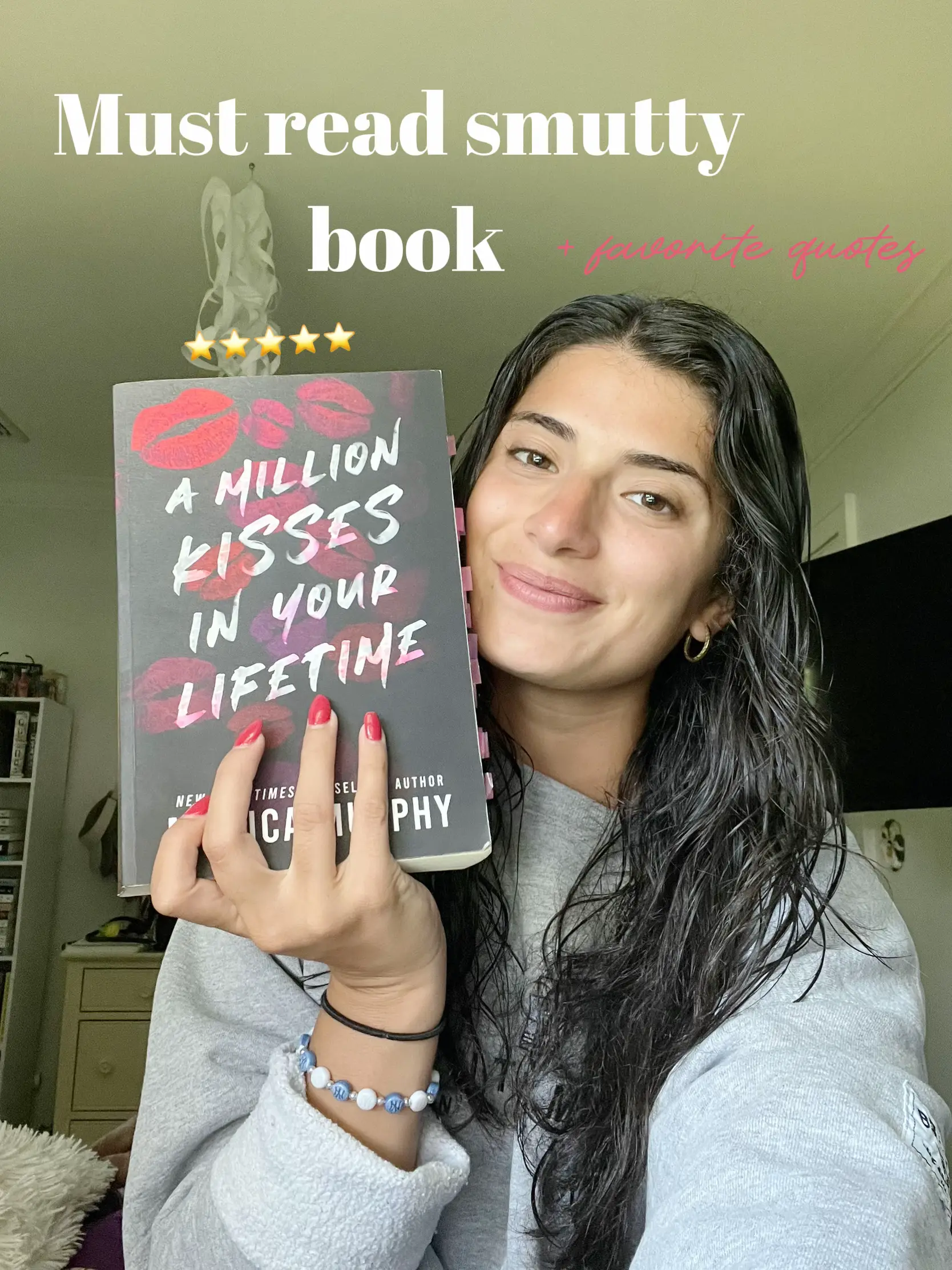  A woman is holding a book titled "A million kisses" in her hand.