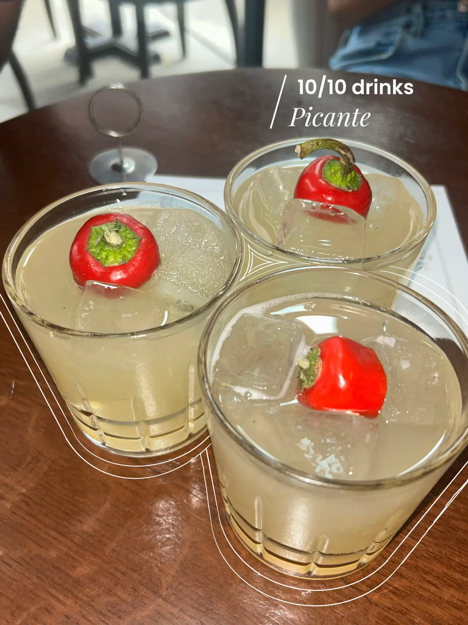  Four glass drinks with a green pepper in the middle.