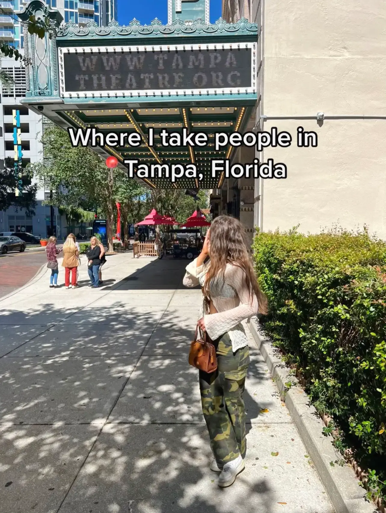  A woman is walking down a sidewalk in Tampa, Florida.