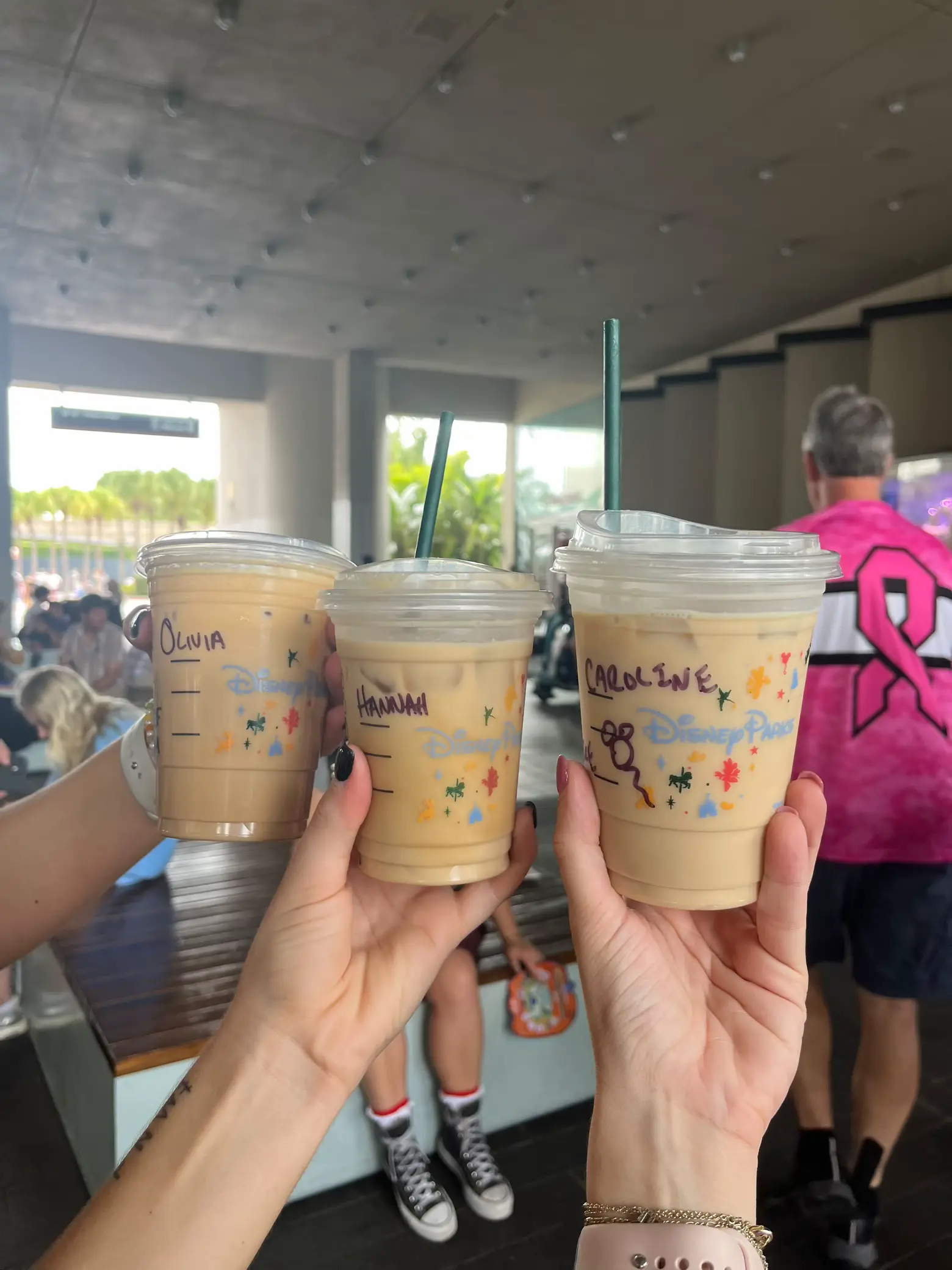  Four people are holding Starbucks drinks in their hands.