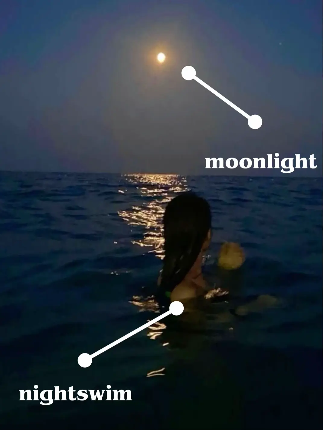  A woman is swimming in the ocean at night.