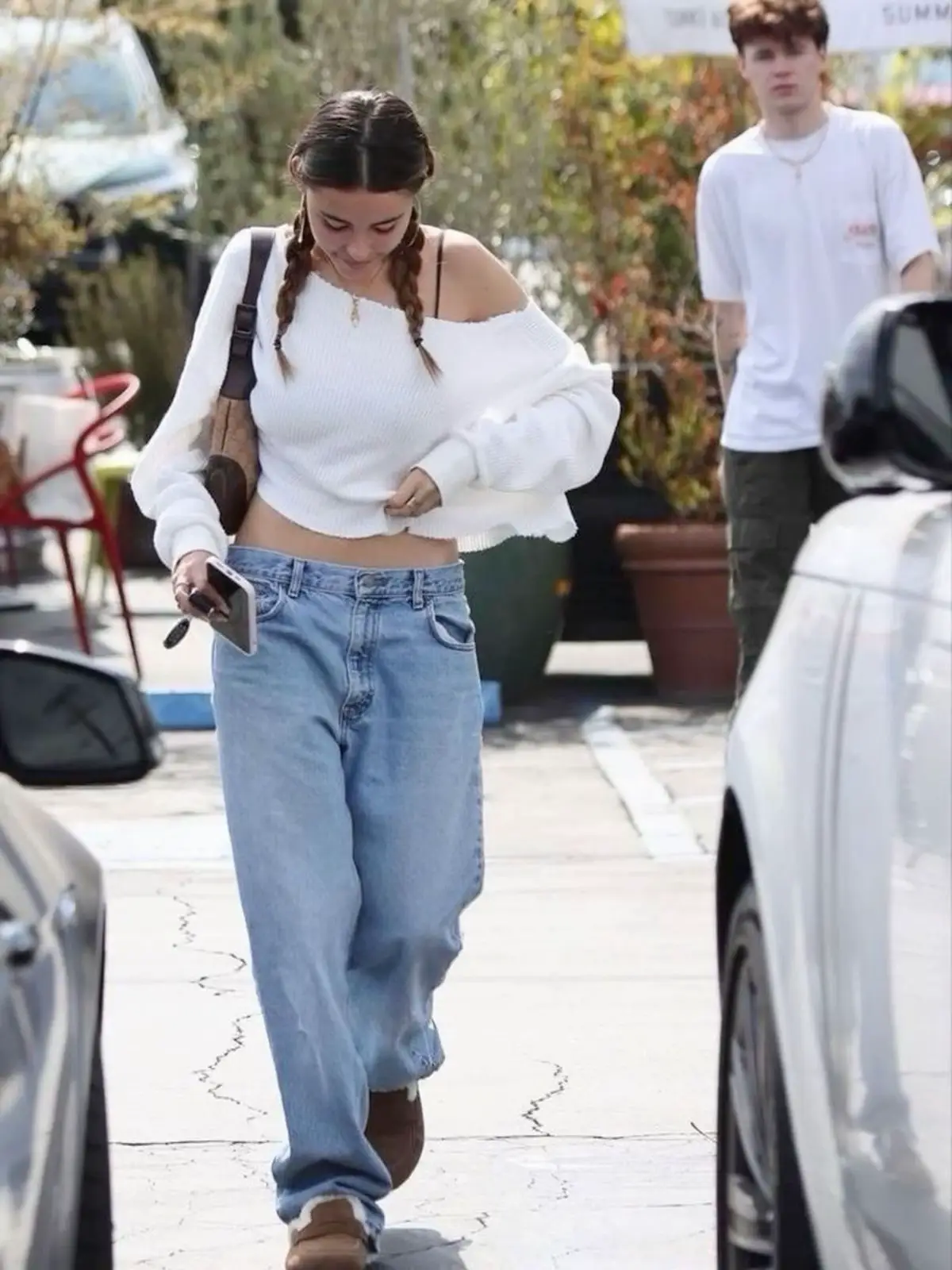 Madison Beer wears a white corset top and ripped jeans while out
