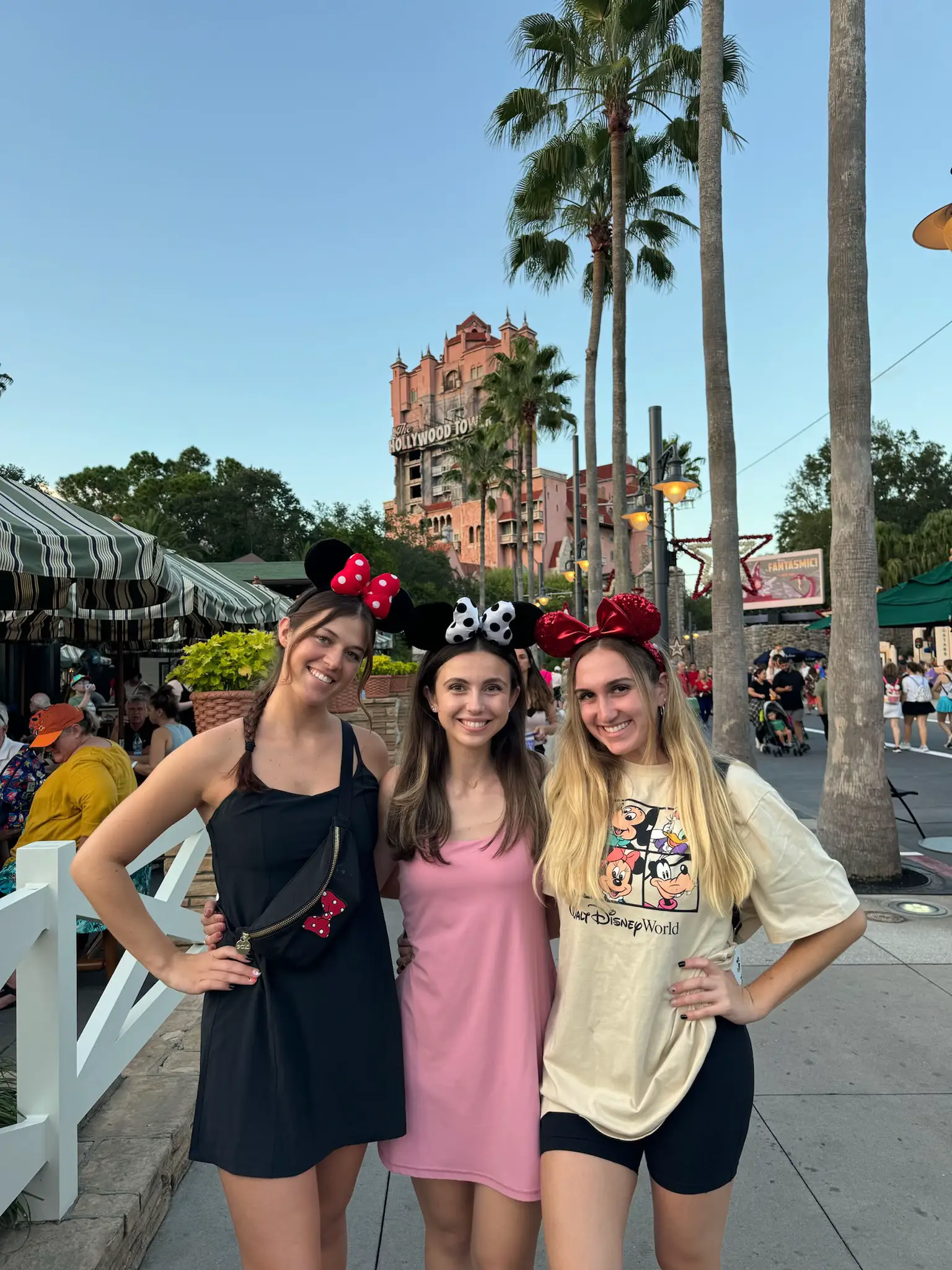  Three women wearing Minnie Mouse ears on their heads.