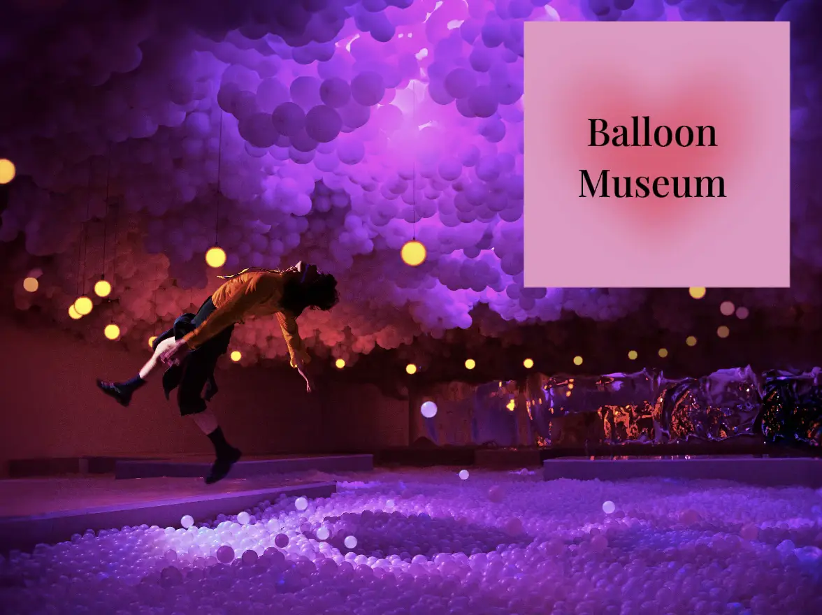  A person is falling into a pool of water at a balloon museum.