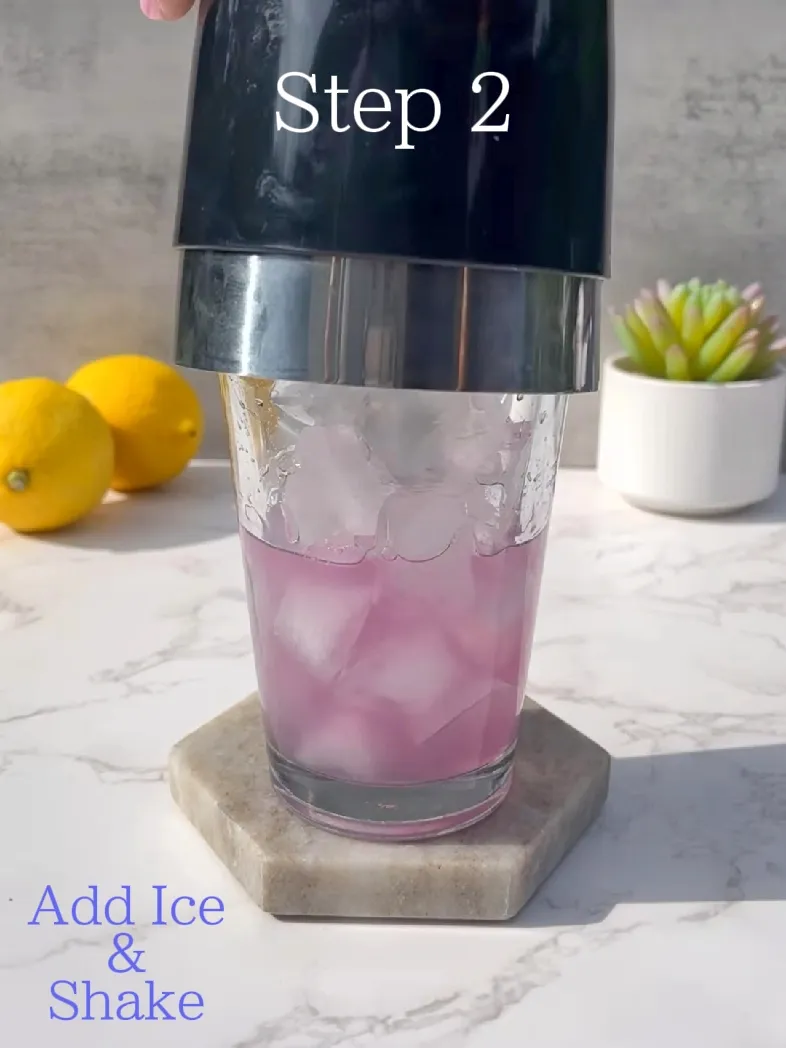  A glass of pink liquid with ice cubes.