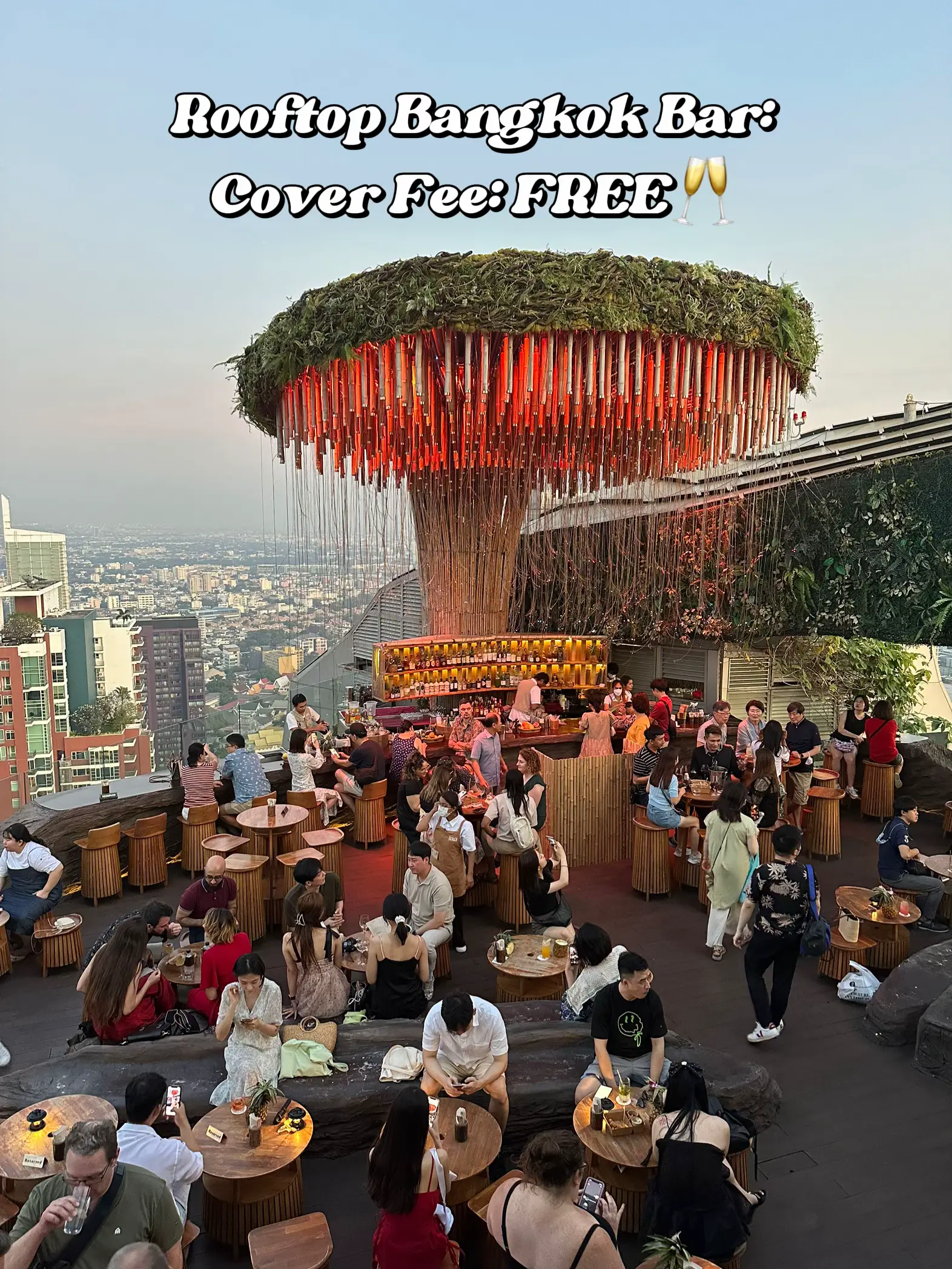  A large group of people are gathered at a rooftop bar. The cover fee is free, and the people are enjoying their time together.