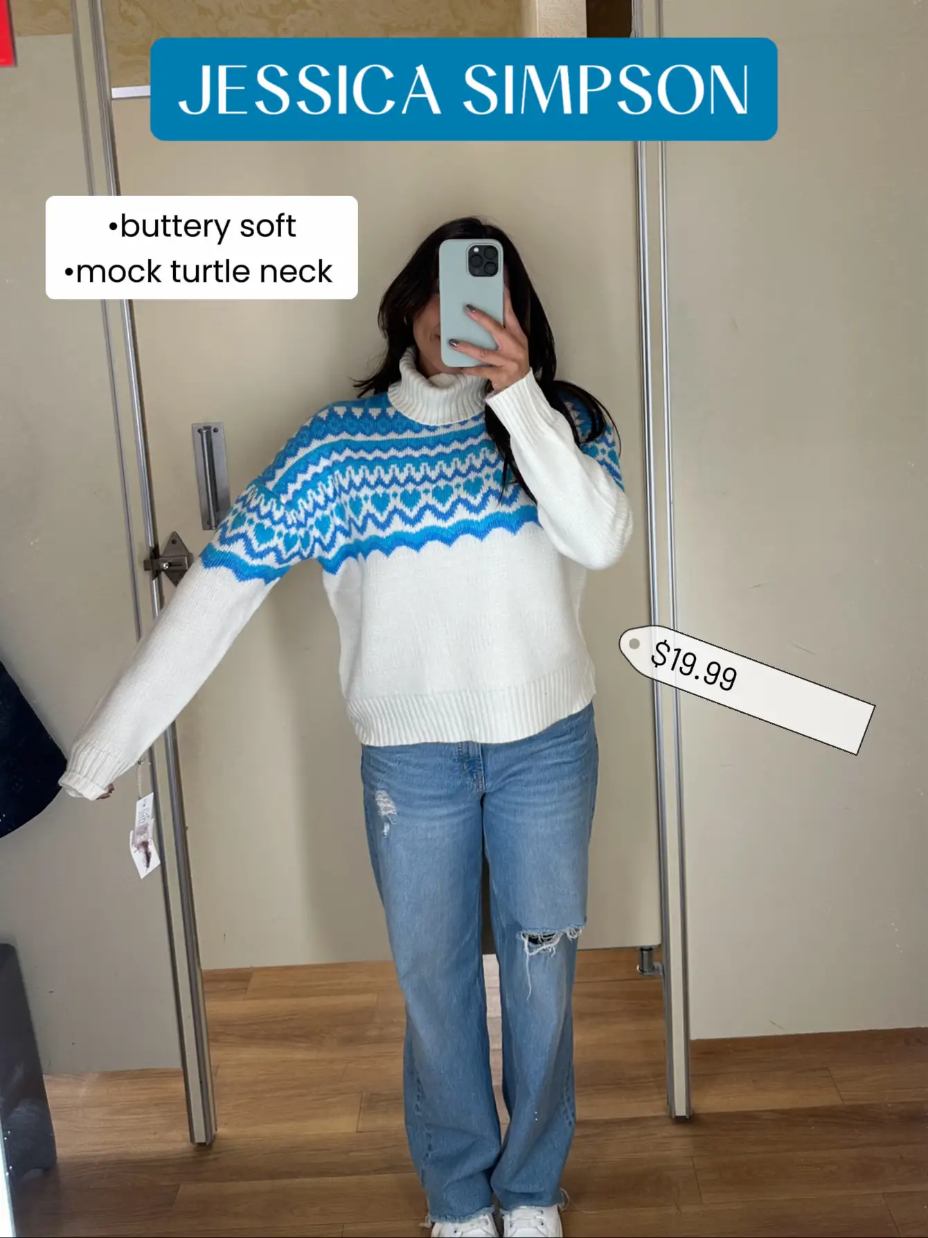  A woman is taking a selfie in a store. She is wearing a brown sweater and jeans. The sweater is described as buttery soft and has a turtle