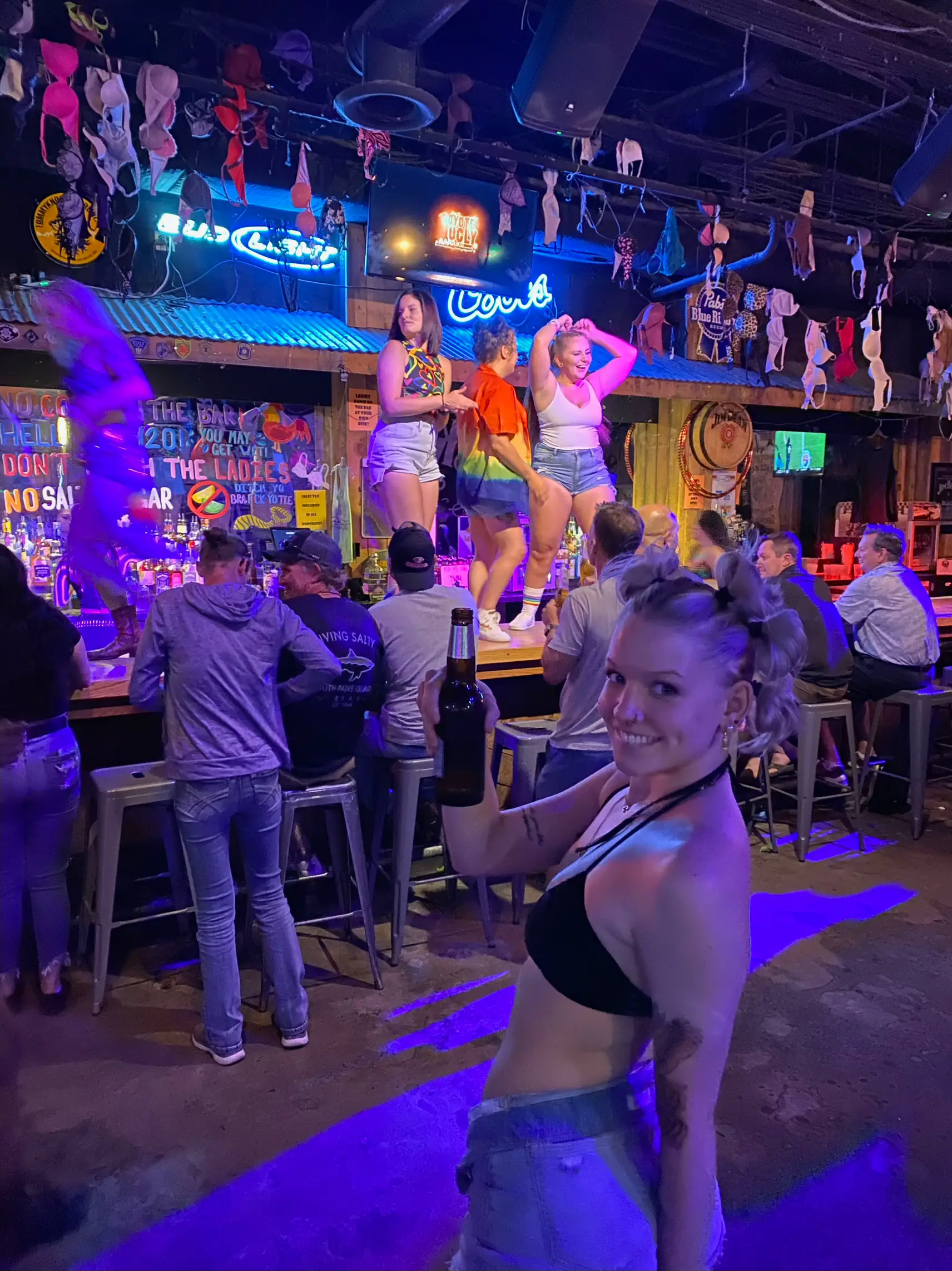  A woman in a bikini is standing in front of a bar