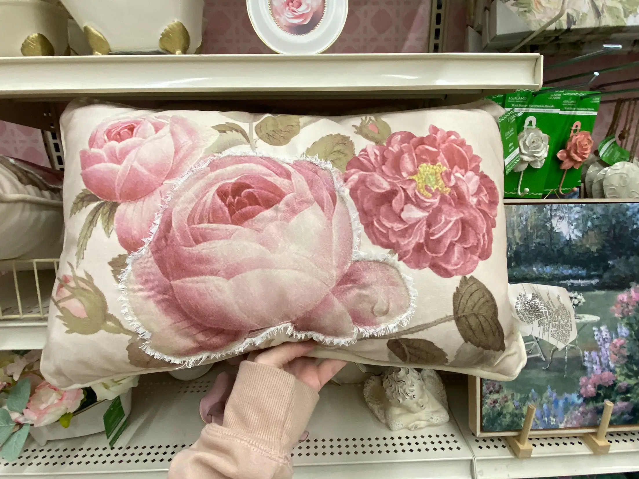  A pink and white flowered pillow with a bird on it.