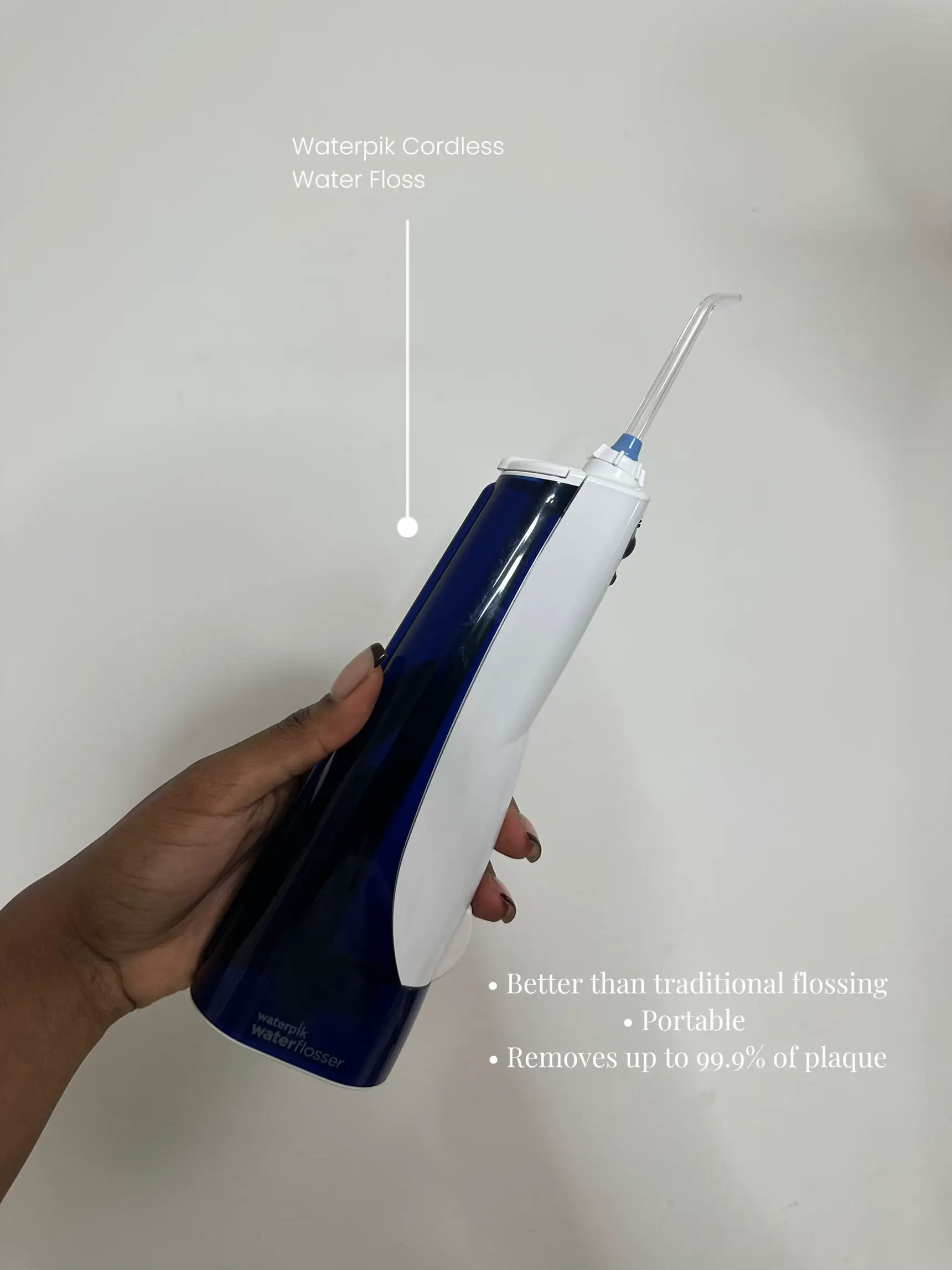 A person is holding a waterpik in their hand.