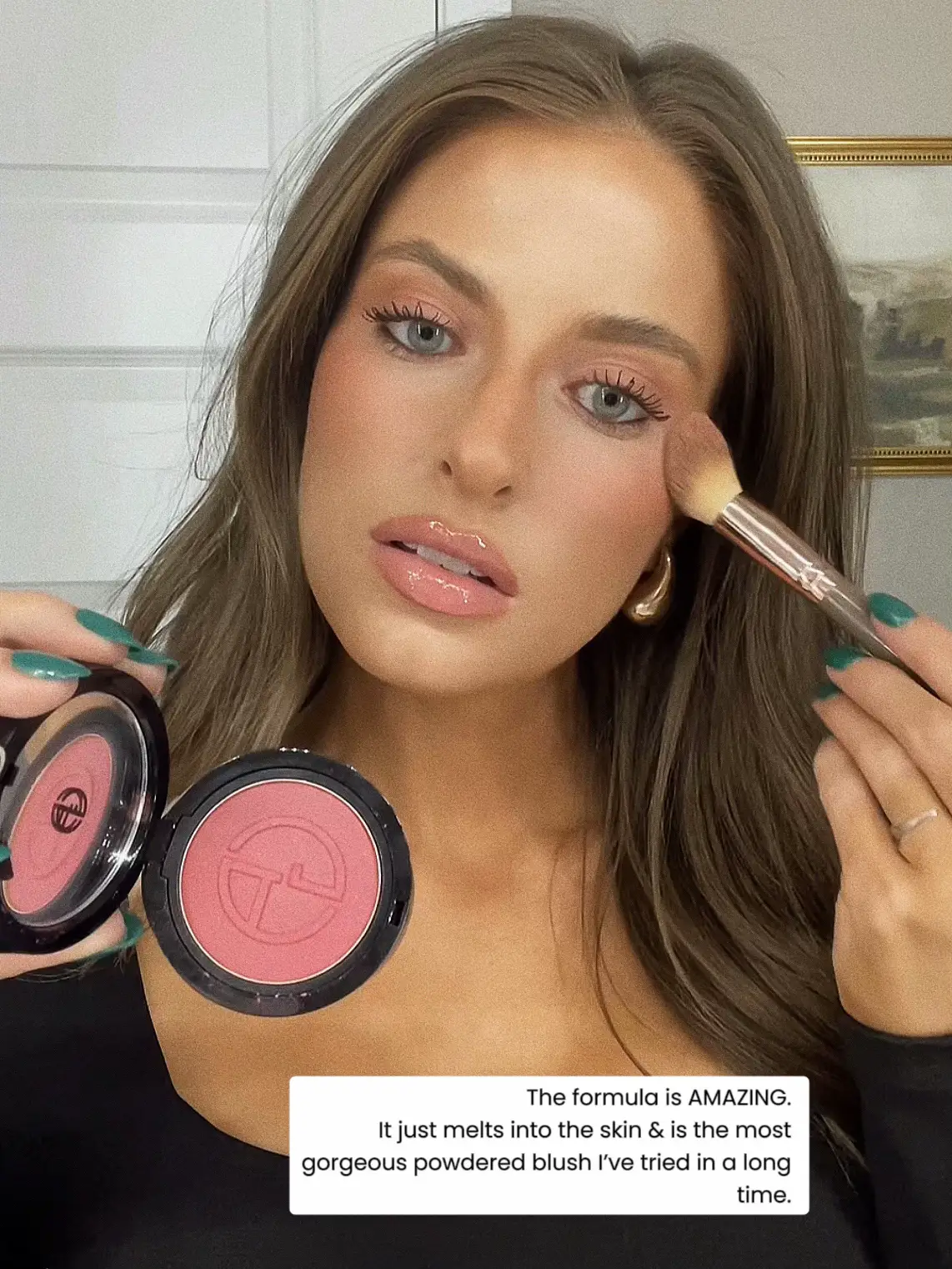  A woman is holding a pink makeup compact in her hand.