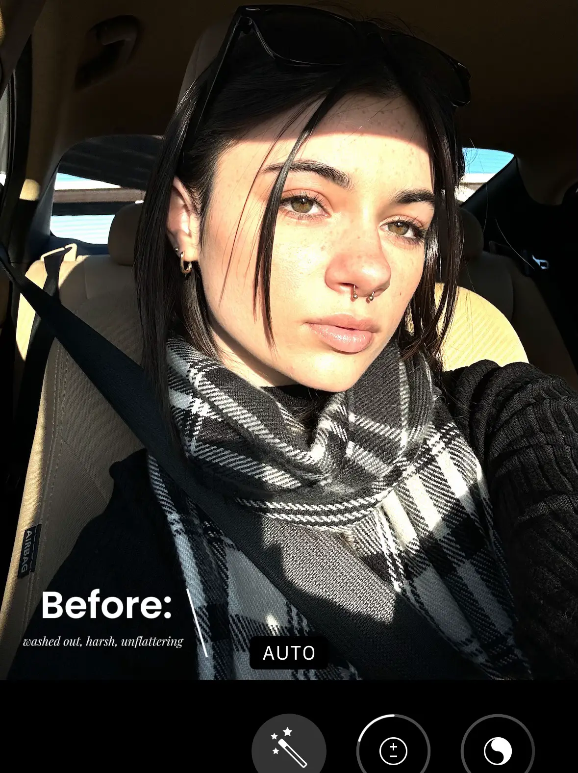  A woman wearing a black sweater and a scarf is sitting in a car.