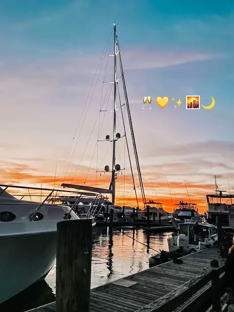  A boat is docked on a pier with a sunset in the background.