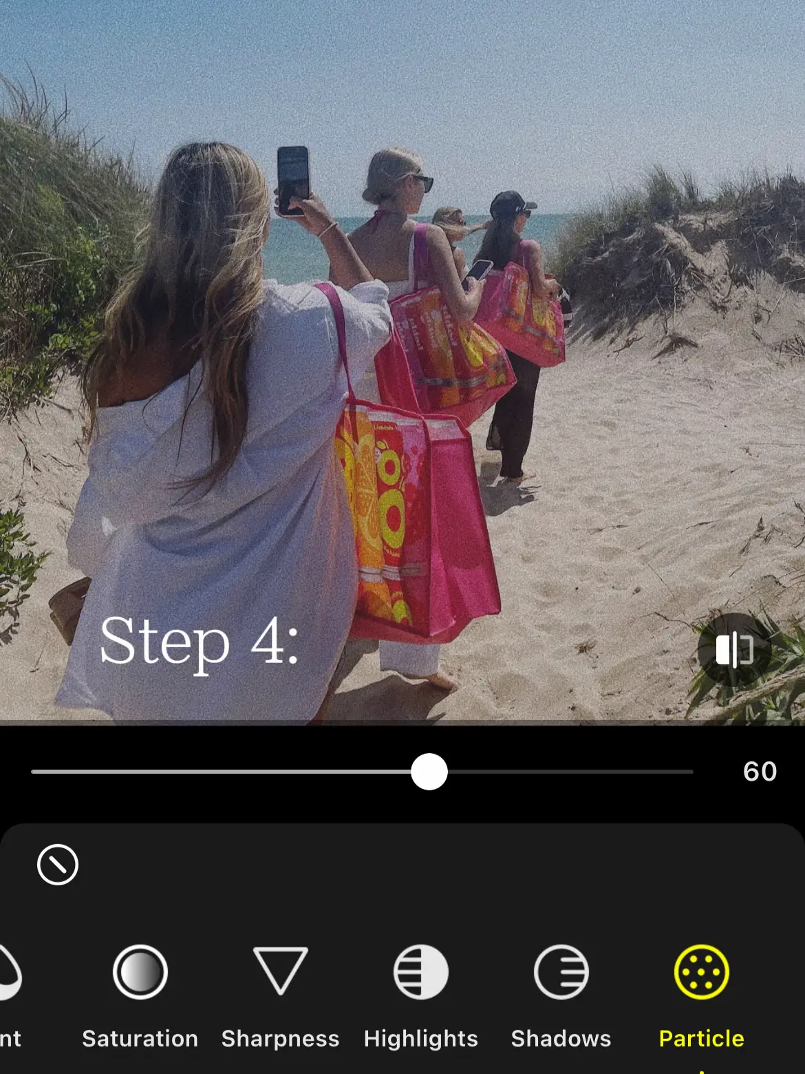  Three women are walking on a beach, with two of them holding bags. The image is taken at a 60 degree angle.