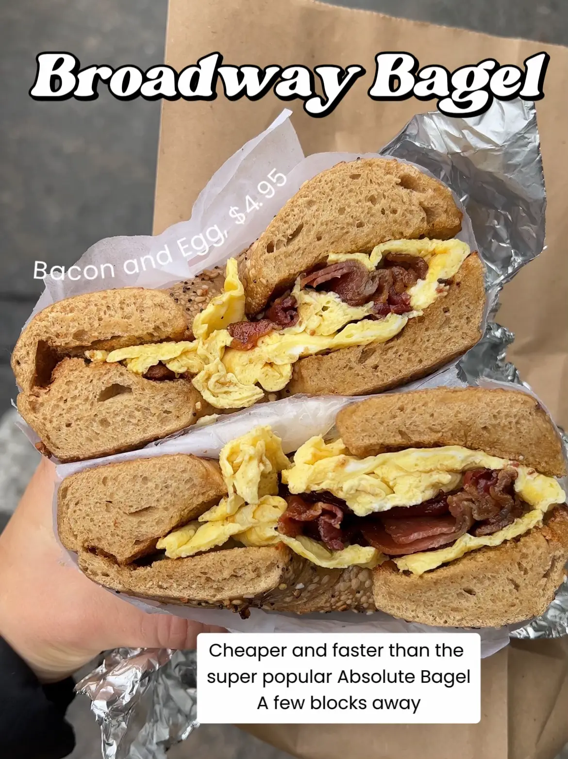  A person is holding a sandwich that includes egg, bacon, and cheese. The sandwich is placed on a piece of tin foil.