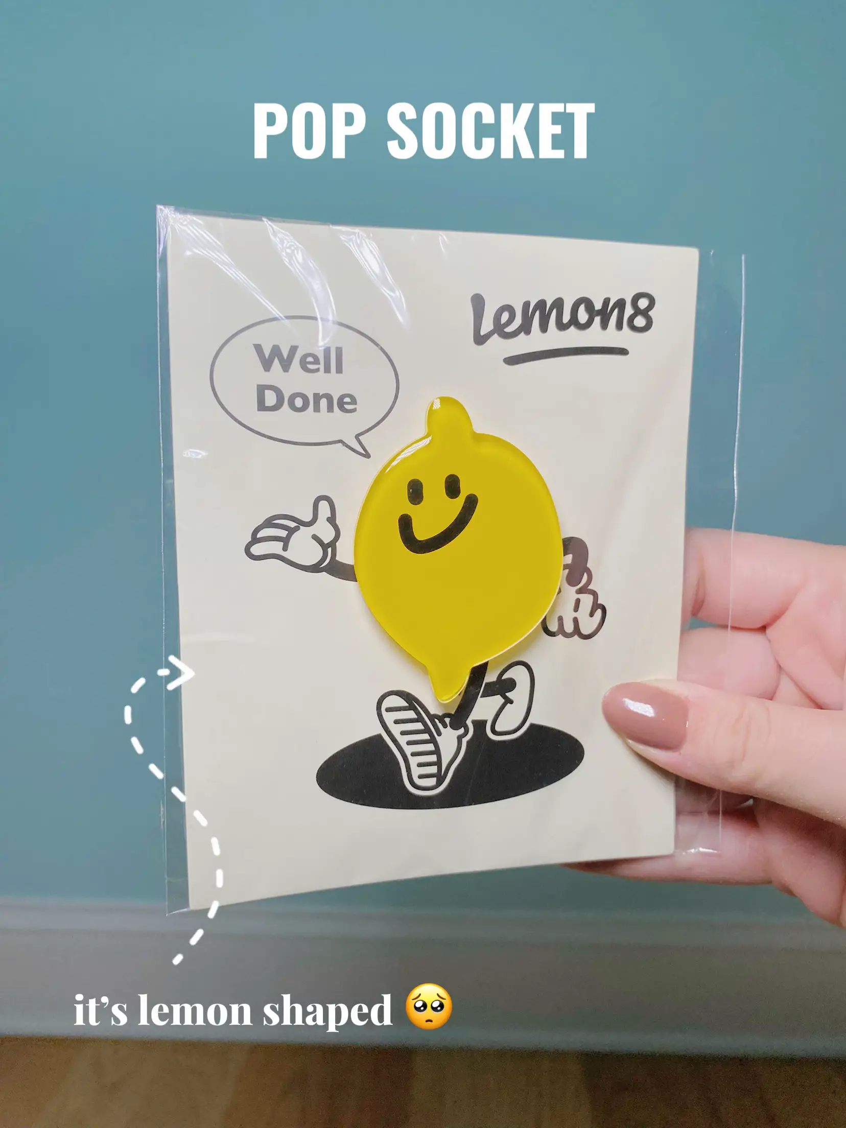  A person is holding a POP SOCKET it's lemon shaped.