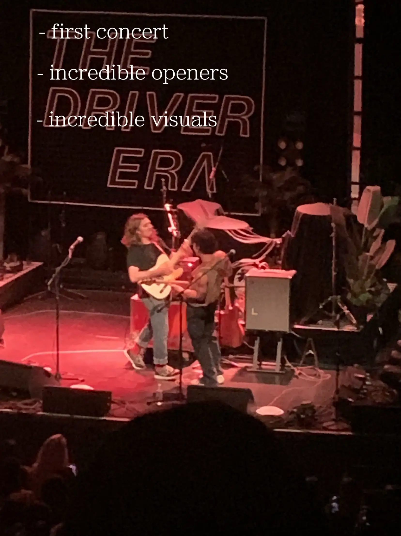  A man is playing guitar in front of another man.